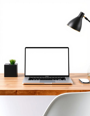 Laptop with blank screen on wooden table and white wall background.の写真素材