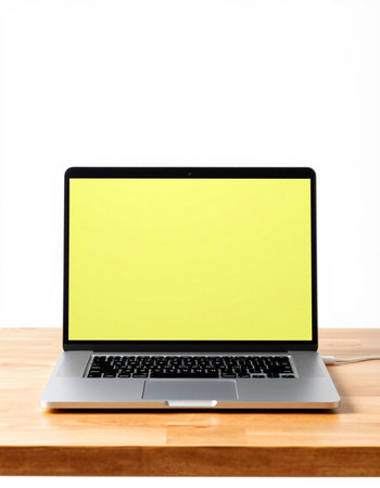 Laptop with blank yellow screen on wood table isolated on white background