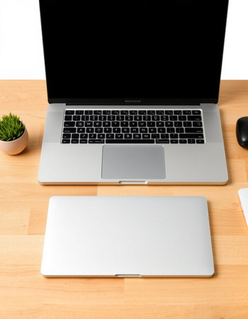 Laptop computer and mouse on a wooden table with a white background