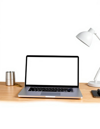Laptop with blank screen on wooden table with lamp and coffee cup