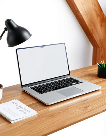Laptop with blank screen on a wooden desk in a modern office