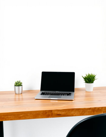 Laptop with blank screen on the wooden table and white wall background