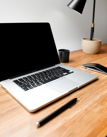 Workplace with laptop and coffee cup on wooden table, closeup