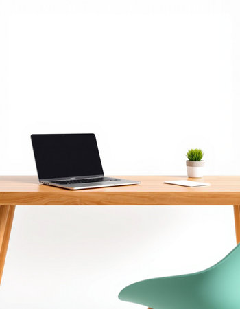 Laptop on a wooden table with a green chair on a white wall backgroundの写真素材
