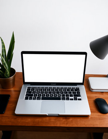 Laptop with blank screen on wooden table in office room, stock photoの写真素材