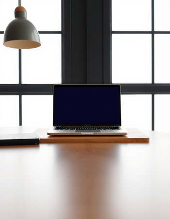 Laptop with blank screen on wooden table in office room, stock photo
