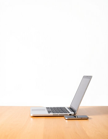 Laptop on wooden table and white wall background. Business concept.