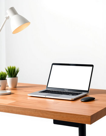 Laptop with blank screen on wooden table and lamp on white wall background