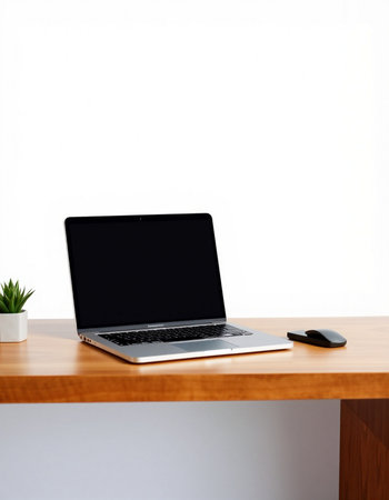 Laptop with blank screen on wooden desk with white wall background.の写真素材