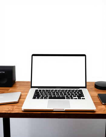 Laptop computer with blank screen on wooden table and white wall backgroundの写真素材