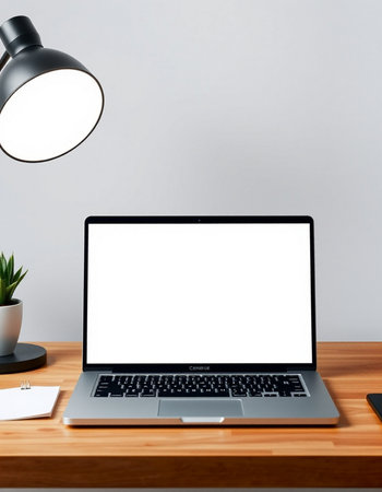 Close up of modern workplace with blank white laptop screen and other items. Mock up