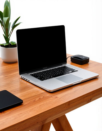 Laptop with blank screen on wooden table and black mobile phone on white backgroundの写真素材
