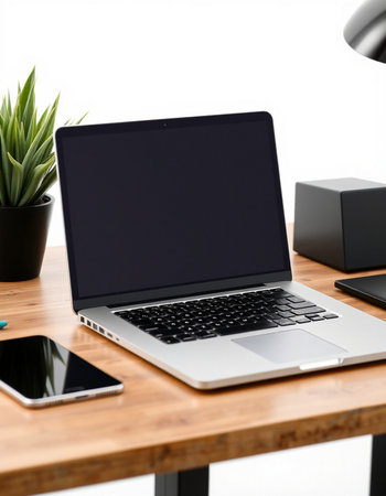 Close up of modern workplace with blank screen laptop computer, smartphone and other items on wooden...
