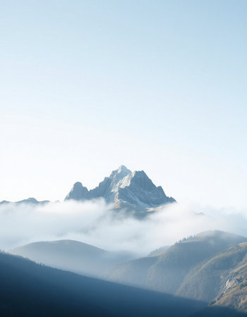 Beautiful alpine landscape with mountain peaks in fog.の写真素材