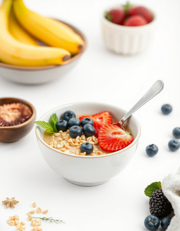 Healthy breakfast with oatmeal, berries and milk on white backgroundの写真素材