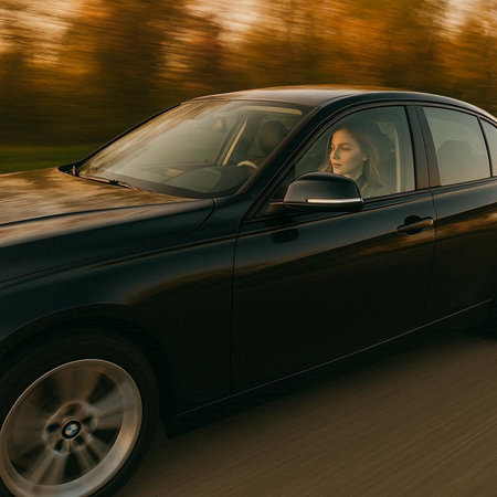 Young woman driving a car on the road. Blurred motion.