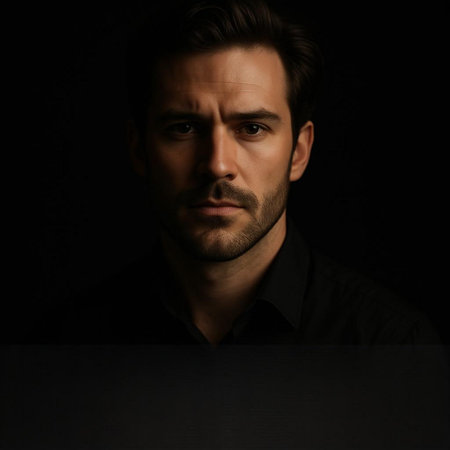 Portrait of a handsome young man in black shirt on black background