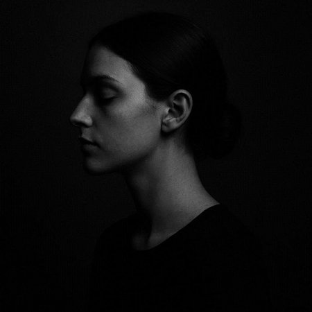 Black and white portrait of a beautiful young woman on a dark background