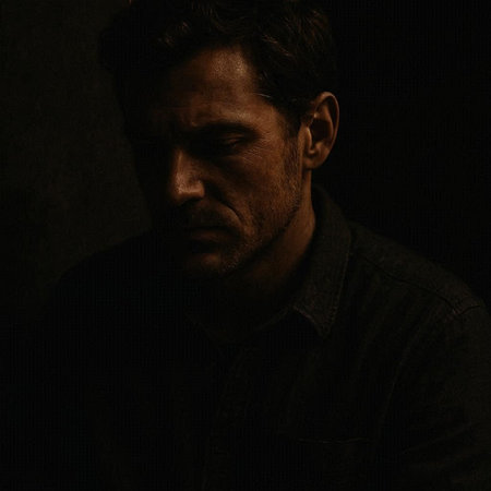 Portrait of a man in a dark room. Studio shot.