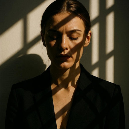 Portrait of a beautiful young woman in a black suit with shadows