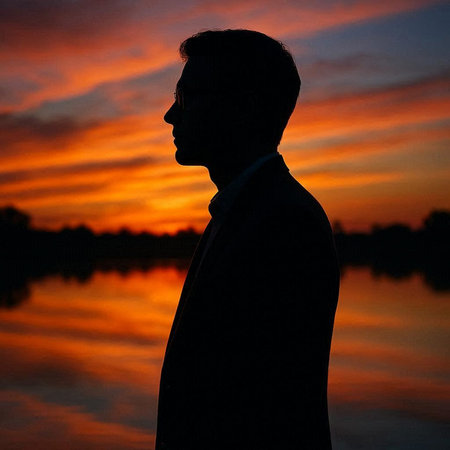 Silhouette of a man in a business suit at sunset.