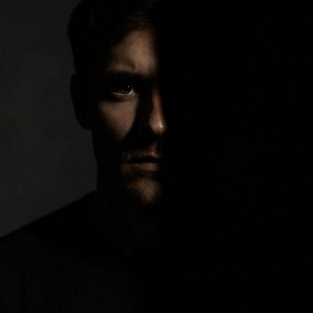 Portrait of a young man in a dark room. Studio shot.