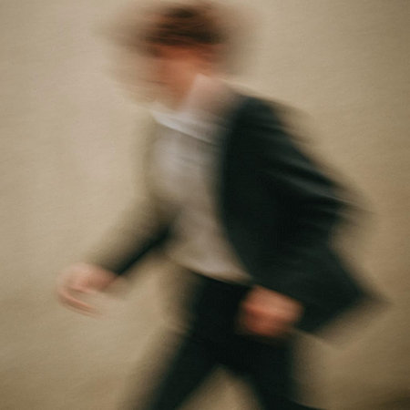 Blurred image of a businessman walking in motion. Intentional motion blur