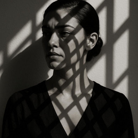 Black and white portrait of a sad young woman with shadow on the wall