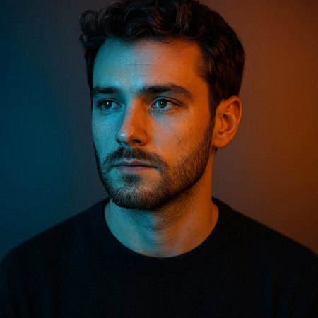 Portrait of a handsome young man with blue light on his face