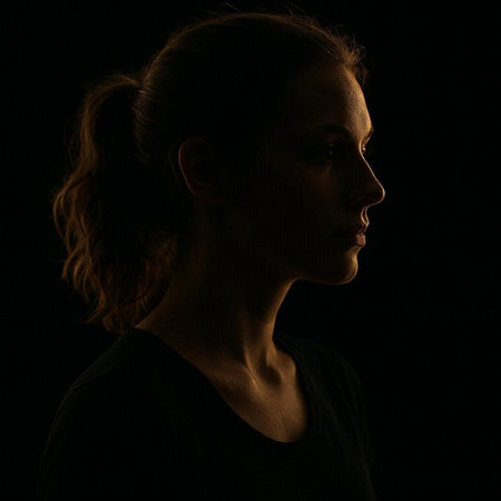 Portrait of a young woman in profile on a black background.の写真素材