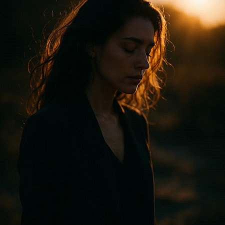 Portrait of a beautiful girl in a black dress on the background of the setting sunの写真素材
