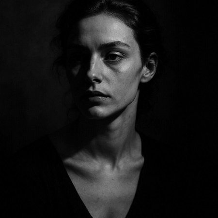 Black and white portrait of a young woman on a dark background.