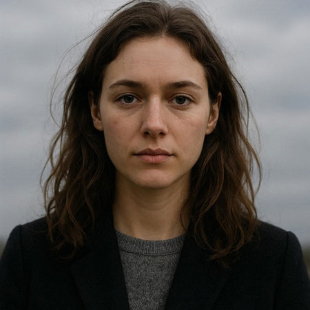 Portrait of a young woman with long brown hair in a black coat
