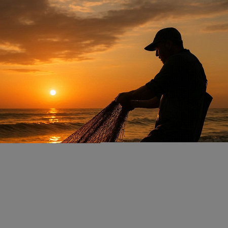 Fisherman holding a fishing net on the beach at sunset.