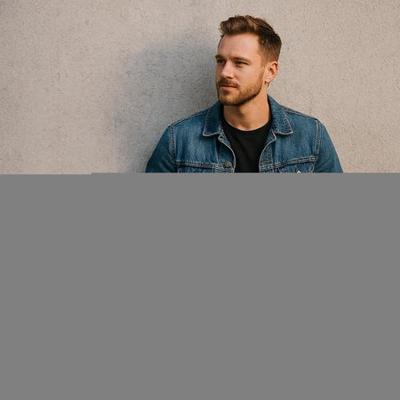Portrait of a handsome man in a denim jacket on a gray backgroundの写真素材