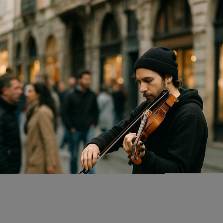 young man playing the violin on the street in european cityの写真素材