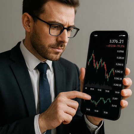 handsome businessman in eyeglasses using smartphone with stock market chart on screen
