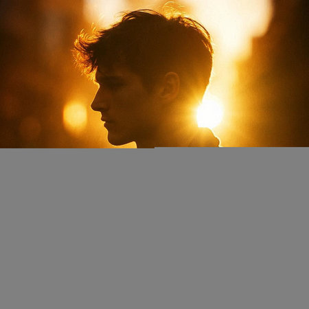 Portrait of a young man in the rays of the setting sun