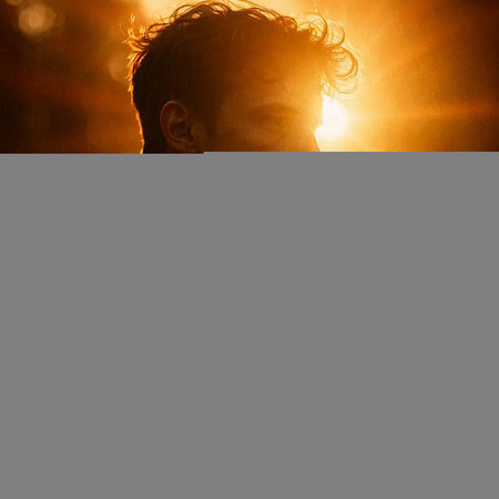 Portrait of a young man in the rays of the setting sun