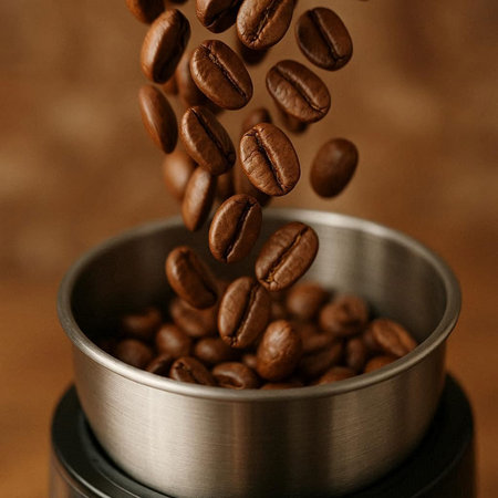 Coffee beans falling into a coffee grinder, close-up