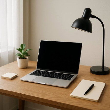 Laptop with blank screen on desk in home office, stock photo