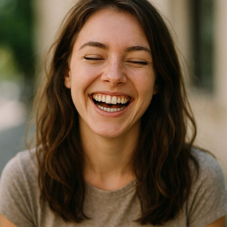 Close up portrait of a beautiful young woman laughing and looking at camera