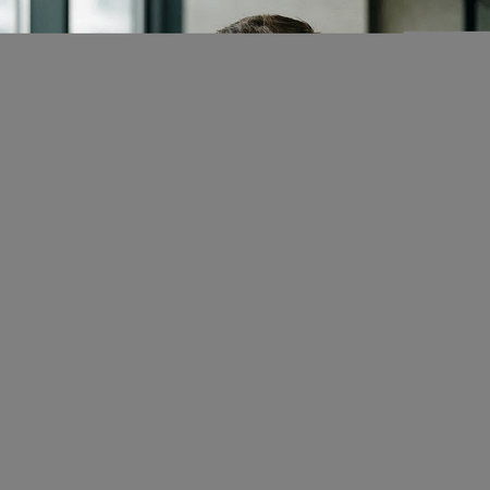 Businesswoman looking through window in office. Young woman looking through window.