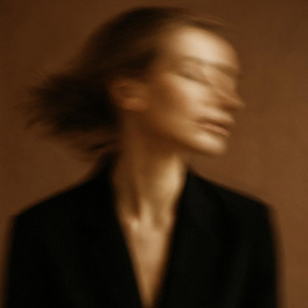 Silhouette of a beautiful woman in a black jacket on a brown backgroundの写真素材