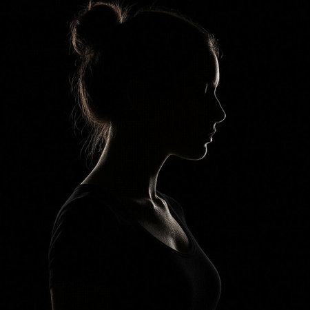 Silhouette of a beautiful young girl on a black background.の写真素材