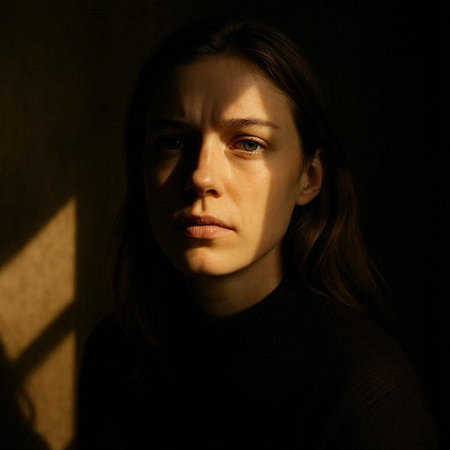 Portrait of a young woman in a dark room with shadows.
