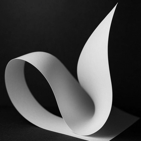 White paper curved corner on black background. Minimalistic design.