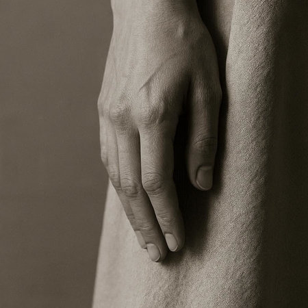 Closeup of a woman's hand holding her dress. Toned.