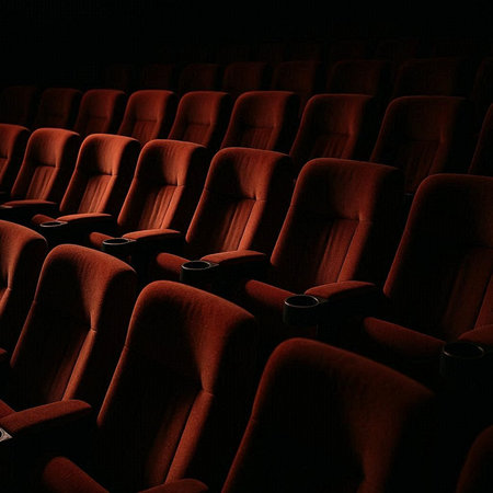 cinema auditorium with red seats and seats in the dark
