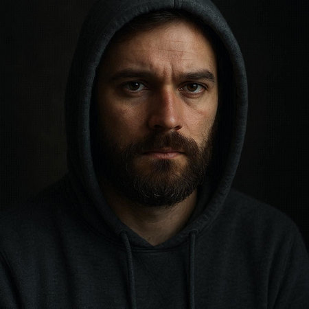 Portrait of a man with a beard in a hood on a dark background